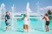 Three young boys playing in the water fountains on a sunny day at White Water in Branson, Missouri.