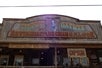 View looking up at an old western style sign for the Olive Oatman Restaurant and Ice Cream Saloon.