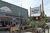 The out door seating area for Judy's Saloon and Pool Hall with men sitting in chair and several large cacti.