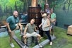 Group strikes a pose in front of a moonshine still