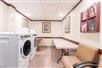 Guest laundry area with coin-operated washer and dryer, folding tables and chairs.