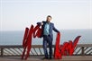 Yakov Smirnoff standing in front of a large red Yakov sign