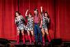 Guest up on stage with showgirls dressed in white and black