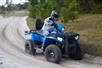 Guest drives a blue Polaris ATV around a curve