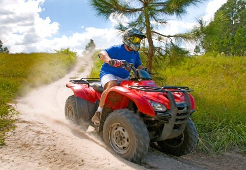 Guest drives a red ATV during an off road adventure