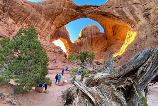 Some people admiring one of these incredible arche formations seen on the Arches National Park Sunset Discovery Tour Moab Utah.