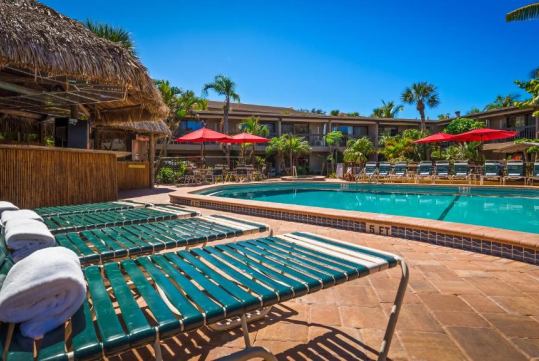 Outdoor pool with sun loungers at Best Western Naples Inn & Suites, FL.