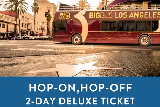 Tour bus driving by the Star Walk and a box saying "Hop-On, Hop-Off 2-Day Deluxe Ticket" with Big Bus Tours in Los Angeles, California, USA.
