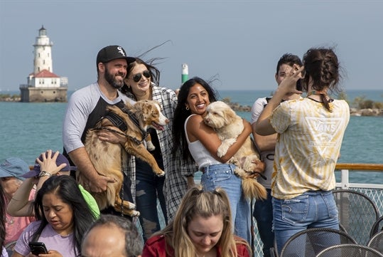 Tour group and their dogs taking photos on the Canine Cruise in Chicago Illinois.