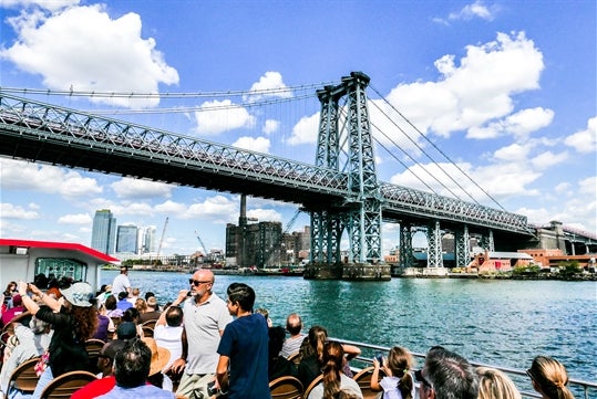 Group of people on the boat viewing the Manhattan Bridge in New York City, New York