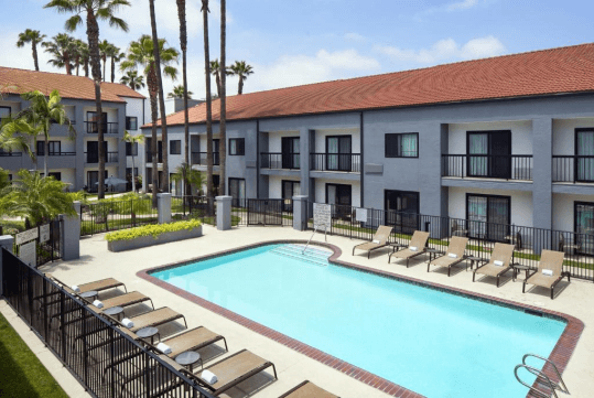 Outdoor pool with sun loungers at Courtyard by Marriott Los Angeles Hacienda Heights Orange County, CA.