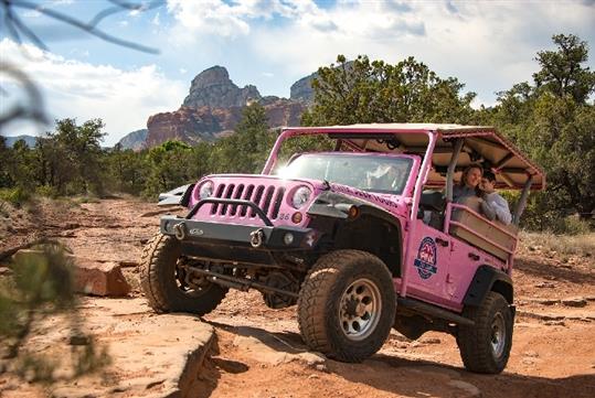 The Pink Jeep Trekker driving over rocks on the Coyote Canyons Pink Jeep Tour in Sedona, AZ