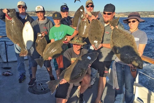 Anglers onboard the fishing boat proudly display their catch of the day.