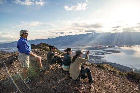 The tour group and guide watching the sun set over the mountains on the Death Valley - Pink Jeep Tour in Las Vegas, NV