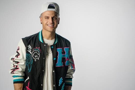 Dustin Tavell photo wearing a white hat and a black and white colored varsity jacket with a letter H design attached to it.