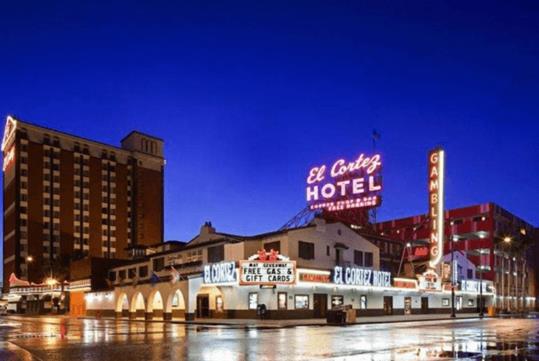 Street view of the El Cortez Hotel and Casino at night with the city lights illuminating it.