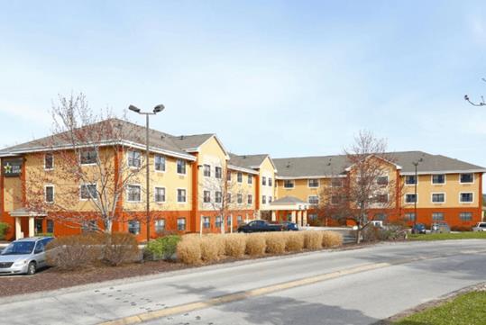 The front exterior and landscaping of the yellow and orange Extended Stay America Suites - Pittsburgh - Carnegie.