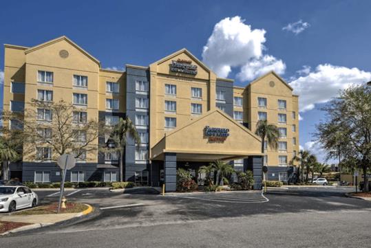 The front exterior of the Fairfield Inn & Suites by Marriott Near Universal Orlando on a sunny day in Orlando, FL