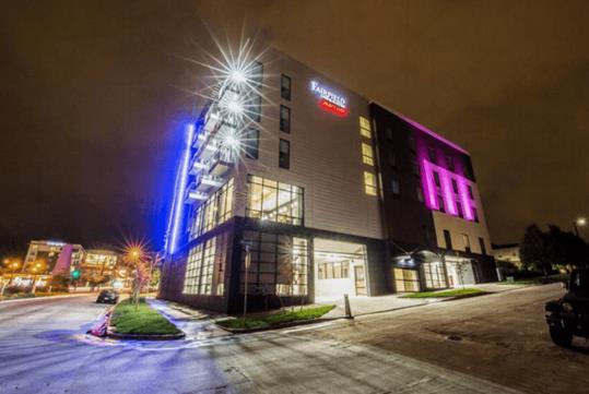 Exterior of the Fairfield Inn & Suites Denver Downtown with blue, pink, and white lights shining bright at night in Denver Colorado.