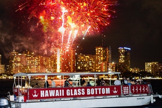 Hawaii Glass Bottom Boat can be seen afloat with the fireworks display.