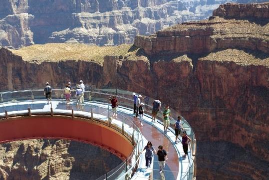 Guest on the Grand Canyon Skywalk enjoying the views of one of the Grand Canyon on a bright sunny day.