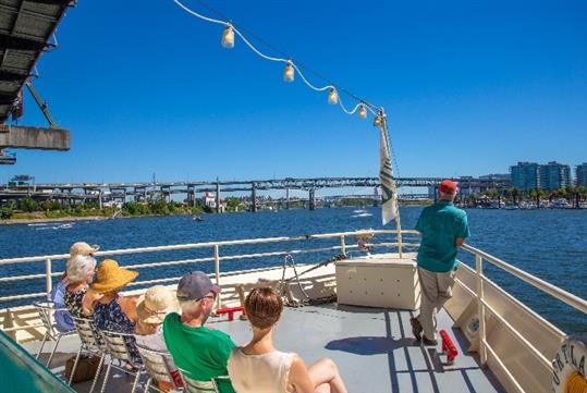 People sunning on the forward deck of the Portland Spirit on a sightseeing cruise.