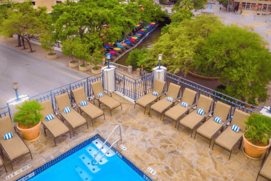 Outdoor pool with sun loungers at Hilton Palacio del Rio, TX. 
