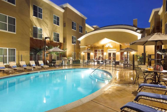 Outdoor pool with sun loungers.