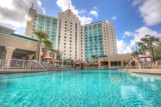 View looking up at the Hotel Kinetic Orlando Universal Blvd from its bright blue swimming pool in Orlando, Florida.