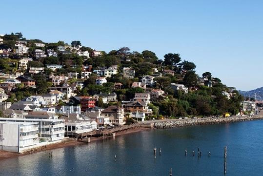 Wide shot of coast line of the city of Sausalito no a sunny day with no boasts in the water on a bright sunny day.