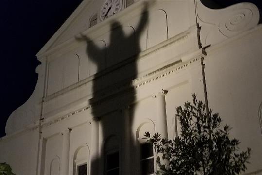A large shadow appears on a building