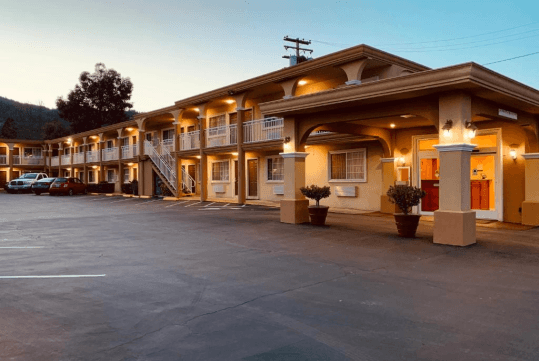 Exterior of the Quality Inn Ukiah Downtown with the outdoor lights on at sunset.