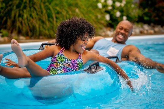 A couple enjoys floating along a lazy river in a blue inflatable tube at Sandcastle in Homestead, Pennsylvania.