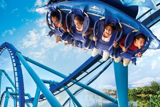 Young adults laughing and screaming while riding the Mako hyper coaster at SeaWorld in Orlando, Florida.