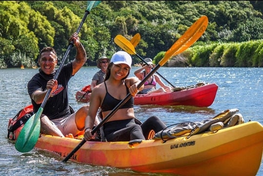 Guests are paddling in their bright yellow kayak in  the majestic Wailua River.