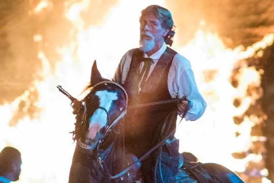 Jim Lane riding a horse with a fire behind him at Shepherd of the Hills Outdoor Drama in Branson, Missouri.