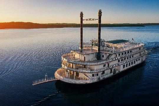 View looking down on the Showboat Branson Belle on the water with the sun setting to the left in Branson, Missouri.