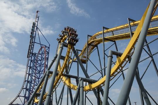 Park guests on the BATMAN™: The Ride, a world-class 4D Free Fly Coaster on a bright and sunny day.