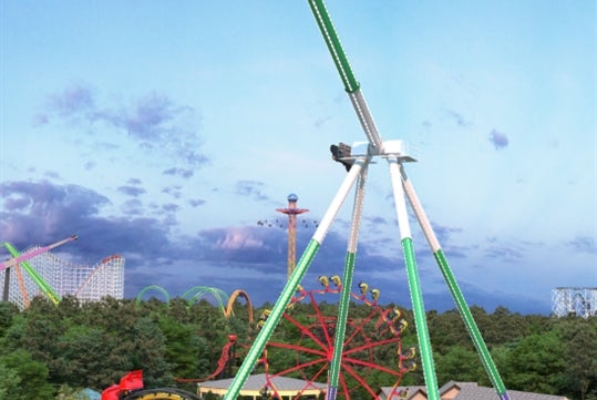 A thrilling amusement park ride that swings riders high above the ground, surrounded by various roller coasters and a lush green landscape.