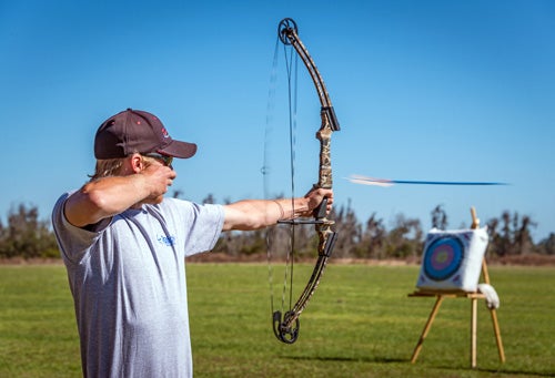 Man with a bow shoots at a target