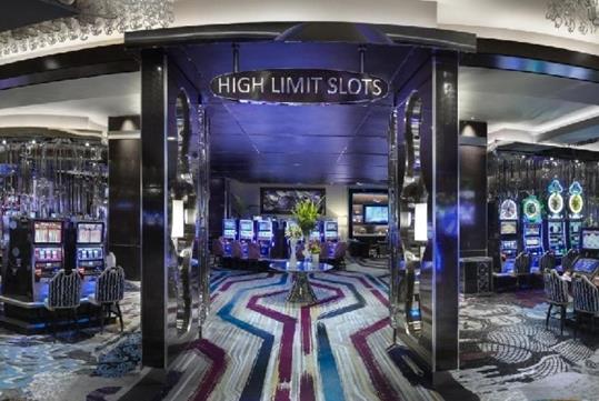 The casino at The Cosmopolitan of Las Vegas with gray purple and blue carpet filled with different types of slot machines.