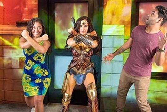 A man and woman posing with a wax figure of wonder woman at Madame Tussauds Orlando.