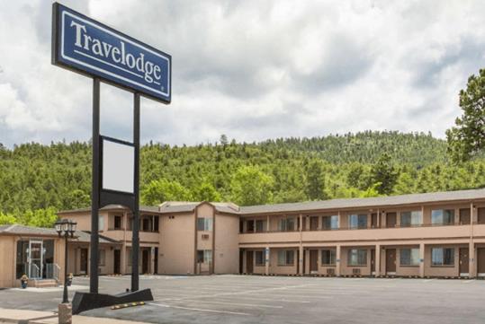 The highway sign and front exterior of the Travelodge by Wyndham Williams Grand Canyon on a cloudy day.