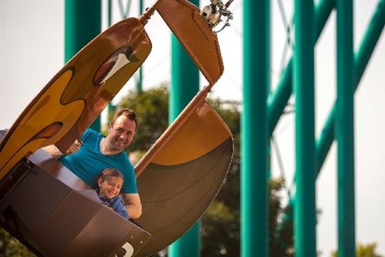 A father and son laughing while riding the Flying Eagles at Valleyfair in Bloomington, Minnesota.