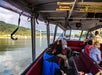 A look at the inside of the Explorer Jetboat with passengers filling the red cushioned seats.