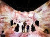 I full view of the art immersed room with several couples in awe and the piano is the centerpiece of the room at ARTECHOUSE Washington DC.