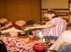 A woman in a pink plaid shirt smiling and serving food to quests at the A Christmas Story Dinner Show.