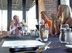 Guests on the VIP Wine Tasting and Dinner Tour smiling and chatting while seated at a table at the Black Oak Grill.