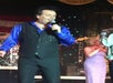 Travis James is dressed to impress in a sharp black vest and silky blue shirt during this on-stage performance at the Main Event Theater.