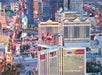 Aerial view of the Las Vegas Strip featuring major hotels and casinos, including Caesars Palace and the Mirage, with bright city lights at dusk.